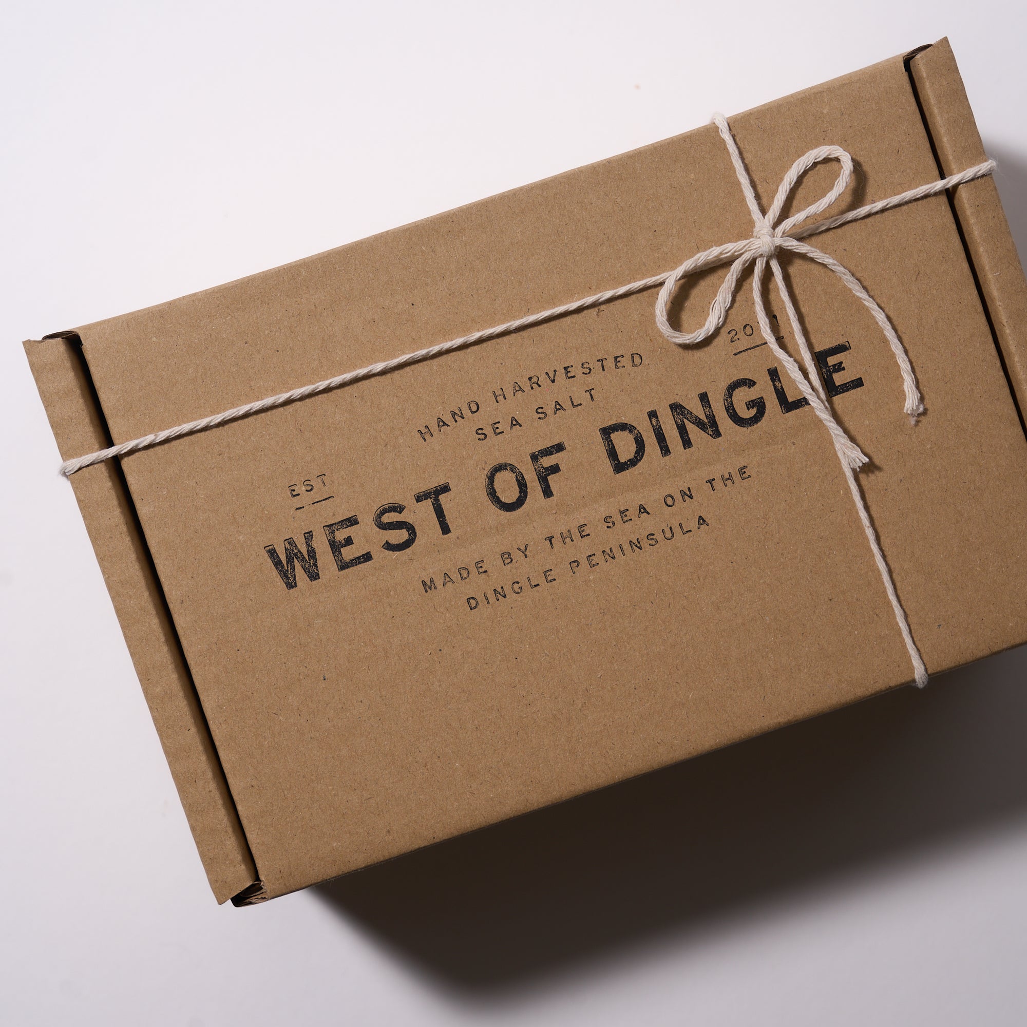 Kraft paper box with 'West of Dingle' branding on a white background