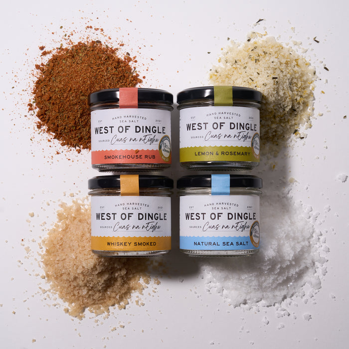 Four jars of West of Dingle sea salt with visible seasoning on a light background